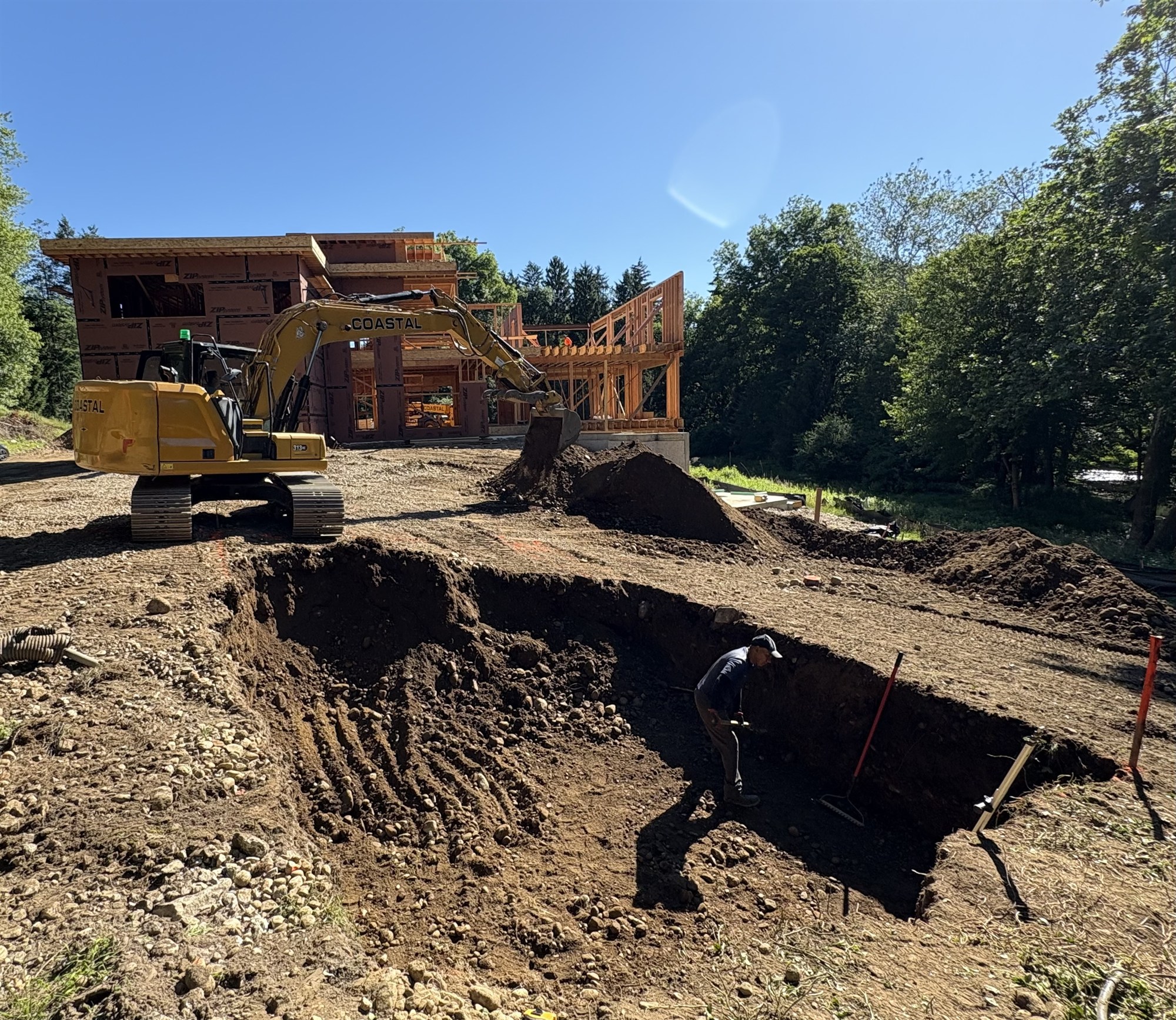 CLH excavator digging a septic system at a custom home