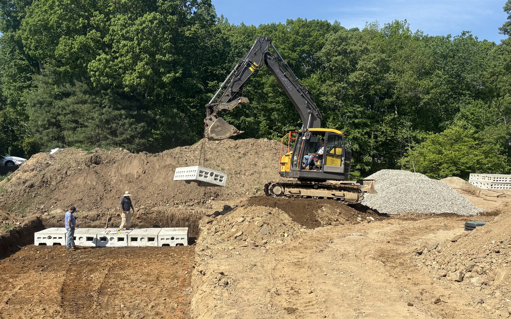 CLH excavator setting precast drainage and retaining structures